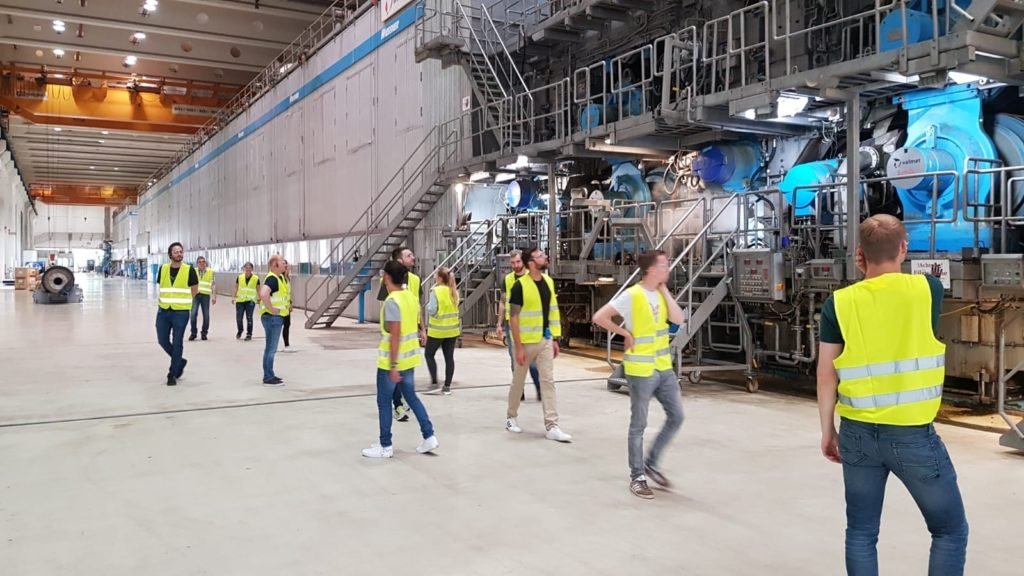 A group of people standing in front of a building
Description automatically generated